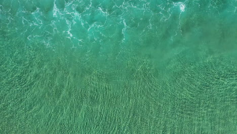 4k-Top-view-aerial-shot-of-small-tide-waves-close-to-the-shore-at-Byron-Bay,-Australia