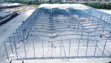 Construction-industry-metal-iron-girder-warehouse-framework-construction-site-aerial-view-slow-dolly-right-shot