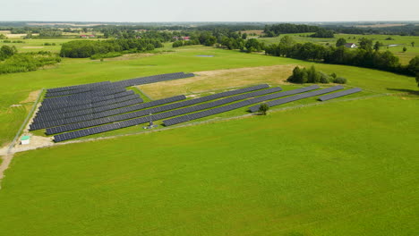 Granja-De-Paneles-Solares-Ecológicos-En-Un-Vasto-Campo-De-Hierba-En-Verano-Cerca-De-Zielenica,-Norte-De-Polonia