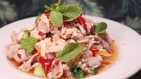Authentic-Thai-Spicy-Pork-Salad-Decorated-with-Mint-on-a-White-Plate