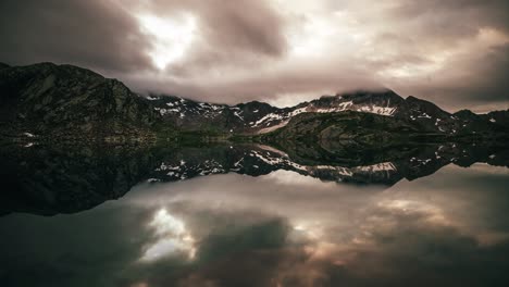 Zeitraffer-In-Den-Bergen-Mit-Reflexionen-In-Einem-See-Und-Sich-Bewegenden-Wolken