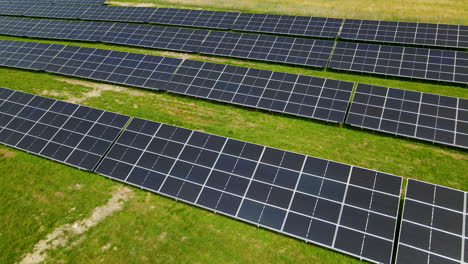 Aerial-shot-of-solar-panel-farm-with-renewable-cells-during-sunny-day-on-meadow