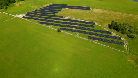 Aerial-view-of-a-green-field-with-solar-energy-panels-for-renewable-electricity-production-in-Poland,-Zielenica-copy-space