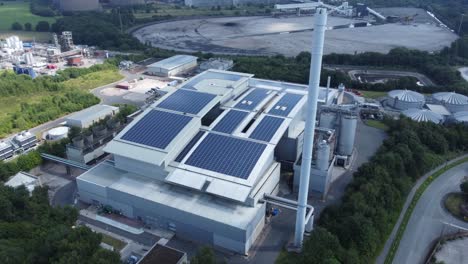 Saubere-Solardachanlage-Auf-Modernem-Bürogebäude-Luftbild-Mit-Kohlekraftwerk-Im-Hintergrund,-Das-Die-Neigung-Nach-Oben-Umkehrt
