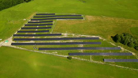 Aerial-View-Of-Blue-Solar-Panels-On-Evergreen-Fields-Near-Countryside-Of-Zielenica-In-Northern-Poland
