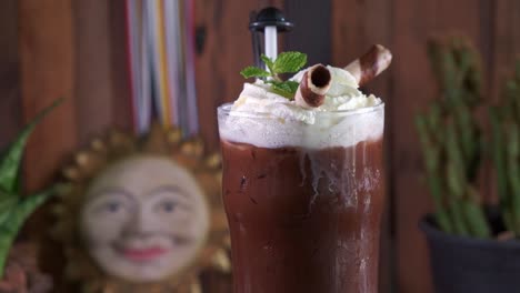 A-Fresh-Chocolate-Drink-with-Whipped-Cram-Decorated-with-Mint-and-Chocolate-Straws-Spinning-in-a-Pint-Glass