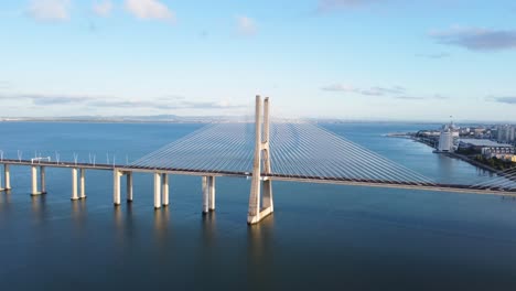AERIAL-Orbiting-Shot-of-Vasco-da-Gama-Bridge,-Revealing-Lisbon-Cityscape,-Portugal
