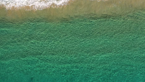 4k-Drone-zoom-out-shot-of-blue-turquoise-ocean-sea-by-the-beach-shore-at-Byron-Bay,-Australia