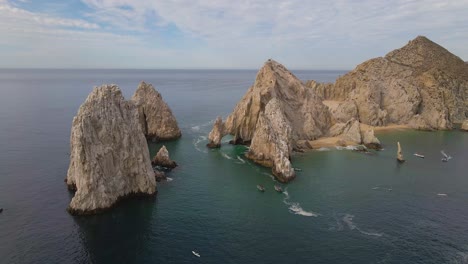 Aerial:-boat-tours-to-Arch-of-Cabo-San-Lucas,-Mexico,-Baja-peninsula