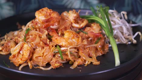 Authentic-Padthai-Freshly-Cooked-on-a-Black-Spinning-Plate-Close-Up-with-Prawns-and-Shrimp