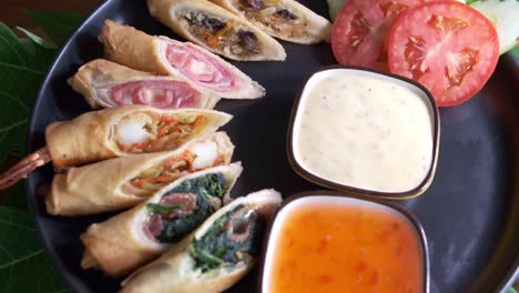 Authentic-Spring-Rolls-on-a-Black-Plate-with-Dipping-Sauce-Rotating-with-Close-Up-Shot