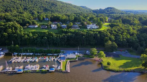 Aerial-drone-footage-of-the-Cornwall-on-Hudson-waterfront-during-summer-as-seen-from-the-Hudson-river,-with-the-Appalachian-mountains-in-the-background