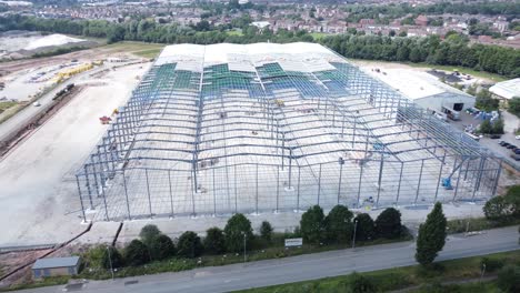 Construction-industry-metal-iron-girder-warehouse-framework-construction-site-aerial-view-upwards-tilt-down