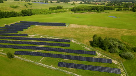 Cinematic-backwards-shot-of-solar-panels-farm-field-of-green-renewable-energy---Poland,Zielenica