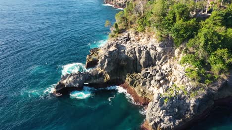 Cinematic-aerial-video-of-Tropical-Island-with-turquoise-water-waves-crushing-rocky-cliffs,-Crystal-Bay-Beach,-nusa-penida,-bali,-Indonesia,-top-down-Aerial-view
