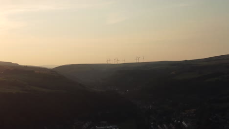 Windturbinen-Öko-Bauernhof-In-Der-Ferne-Auf-Der-Wunderschönen-Berglandschaft-Der-Goldenen-Stunde-Am-Abend