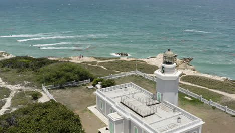 Aerial-pull-out-reveal-of-Faro-Morrillos-Cabo-Rojo-Lighthouse-on-top-of-limestone-cliffs-in-Puerto-Rico