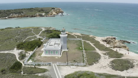 Point-of-interest-aerial-shot-of-the-Cabo-Rojo-Faro-Morrillos-Lighthouse-Puerto-Rico-on-top-of-limestone-cliffs-overlooking-the-Caribbean