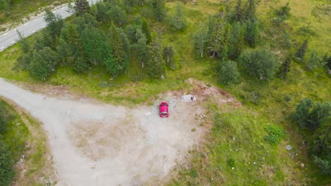 Top-view-of-car-and-camping-tent-next-to-road-and-forest,-Aerial-Ascending