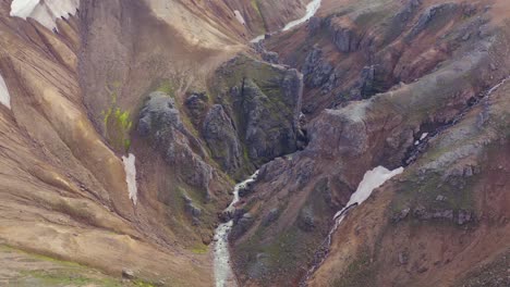 Jagged-rocky-canyon-in-Kerlingarfjoll-valley-of-Iceland-with-river-of-melting-snow