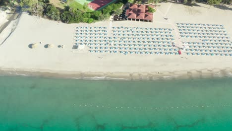Aerial-view-of-beautiful-sea-and-beach-with-parasol-at-sunny-day,-Simeri-Mare,-Calabria,-Southern-Italy