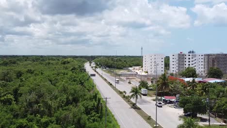 aerial-view-of-juan-dolio-highway-in-dominican-republic,-light-traffic-with-tourist-hotels-and-beach-in-background-view