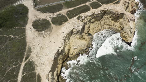 Birds-eye-view-following-the-limestone-cliffs-with-tilt-up-reveal-of-the-Faro-Morrillos-lighthouse-in-Cabo-Rojo-Puerto-Rico