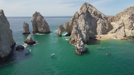 Aerial:-The-Arch-of-Cabo-San-Lucas-popular-tourist-destination,-pull-away-reveal