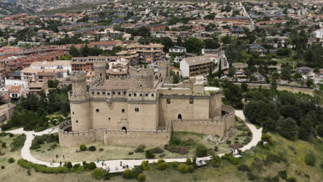 Aerial-over-the-New-Castle-of-Manzanares-el-Real-with-smooth-tilt-up-to-reveal-the-surrounding-town-and-the-stunning-Sierra-de-Guadarrama-foothills