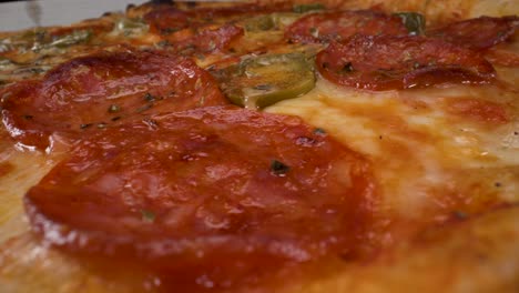 rotating-macro-close-up-view-of-pepperoni-jalapeño-pizza-filmed-in-4k-with-probe-lens,-fast-food,-greasy