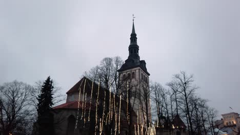Estonia,-Tallinn,-decorated-St-Nicholas-Church-in-the-Old-Town-moving-from-the-top-towards-the-ground-level-on-a-cloudy-winter-day