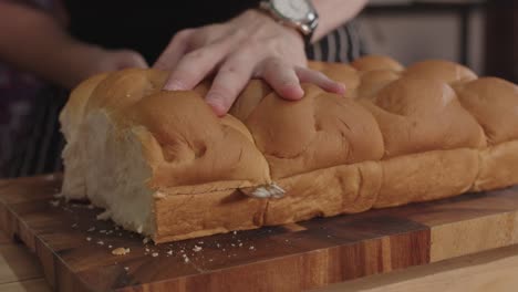 Close-up-on-cutting-dinner-rolls-bun-bread-with-long-serrated-knife
