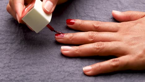 Woman-Painting-Her-Nails-with-Red-Nail-Polish