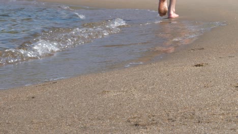Man-Walking-Barefoot-On-Beach,-Along-Waves,-Freedom-Concept,-Low-Angle