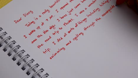 Handwriting-a-Diary-with-a-Red-Pen-Overhead-Shot-Close-Up-of-Woman's-Hand