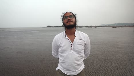 indian-long-hair-boy-walking-on-beach-gorai-india-vivekanand-ingle-talking-on-phone-sand-sea-front