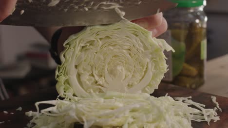 Slicing-cabbage-on-cut-board-with-steel-kitchen-knife