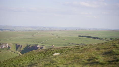 Handheld-shot-of-three-sheep-in-distance-on-top-of-Mam-Tor,-Castleton,-Peak-District,-England