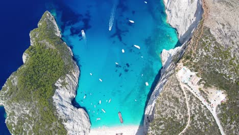 Popular-Navagio-Beach---Boats-On-Turquoise-Blue-Water-Of-Coast-Of-Zakynthos-In-Greece