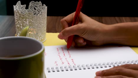 Handwriting-a-Diary-with-a-Red-Pen-Close-Up-of-Woman's-Hand