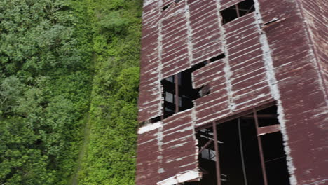 A-weather-worn-rusty-abandoned-old-factory-is-being-reclaimed-by-mother-nature-in-the-heart-of-the-jungle