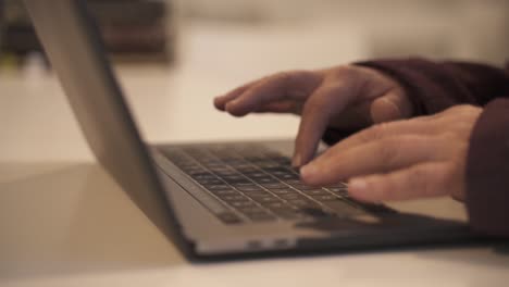 Close-up-of-old-female-hands-typing-slow-on-laptop-at-work-in-office,slow-motion