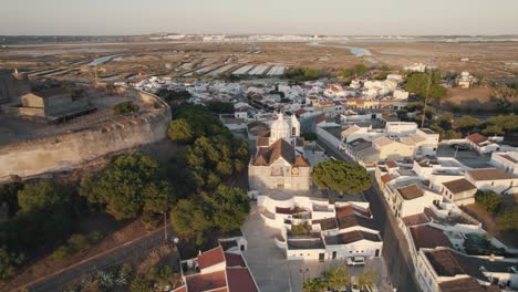 Aerial-pull-out-shot-reveals-the-town-square-of-Church-of-Our-Lady-of-Martyrs-in-Castro-Marim