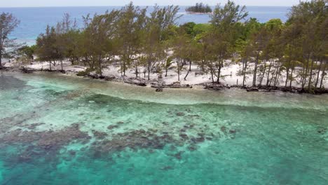 White-Sandy-beach-on-tropical-island-surrounded-by-coral-reef,-aerial-view