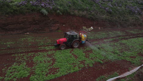 drone-shot-in-tracking-on-tractor-spraying,-potato-plantations