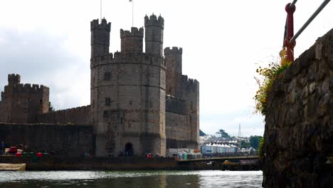 Historic-Caernarfon-castle-Welsh-medieval-harbour-waterfront-town-landmark-dolly-slow-right