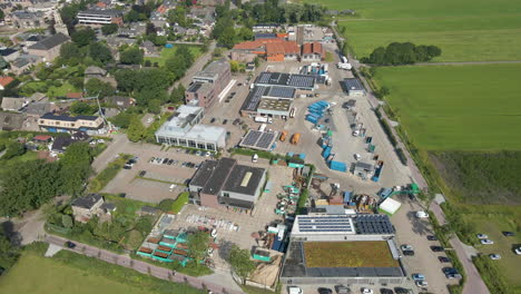 Aerial-of-busy-recycling-station-with-solar-panels-on-the-rooftops-of-buildings