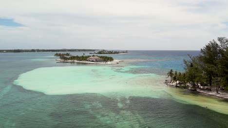 Sandy-beach-on-tropical-islands-surrounded-by-coral-reef,-top-view