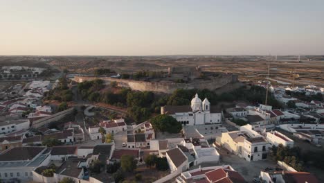 Aerial-panning-profile-view-of-catholic-church-of-Our-Lady-of-Martyrs-in-Castro-Marim,-Algarve