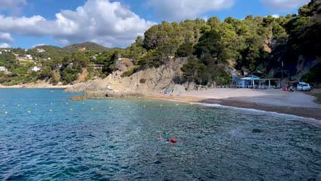 Costa-Brava-beautiful-virgin-beach-with-transparent-turquoise-waters-lush-vegetation-Gerona-Catalonia-Mediterranean-Panoramic-views-Tossa-de-Mar-cove-Llevad?